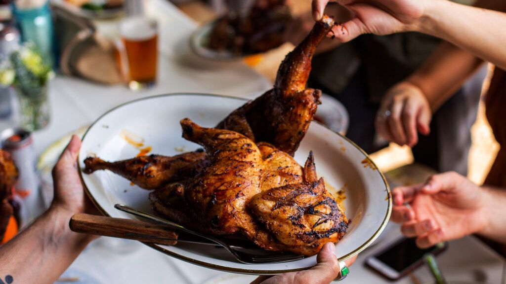 A person is serving chicken.