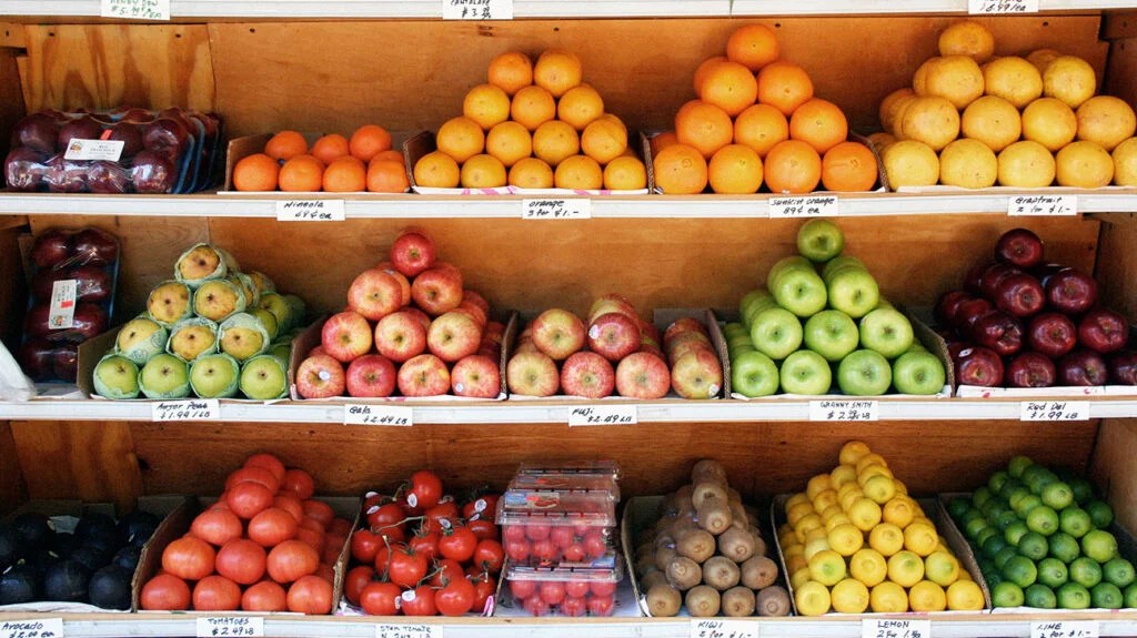 A selection of fresh fruits that may help lower blood pressure stacked on shelves.-2