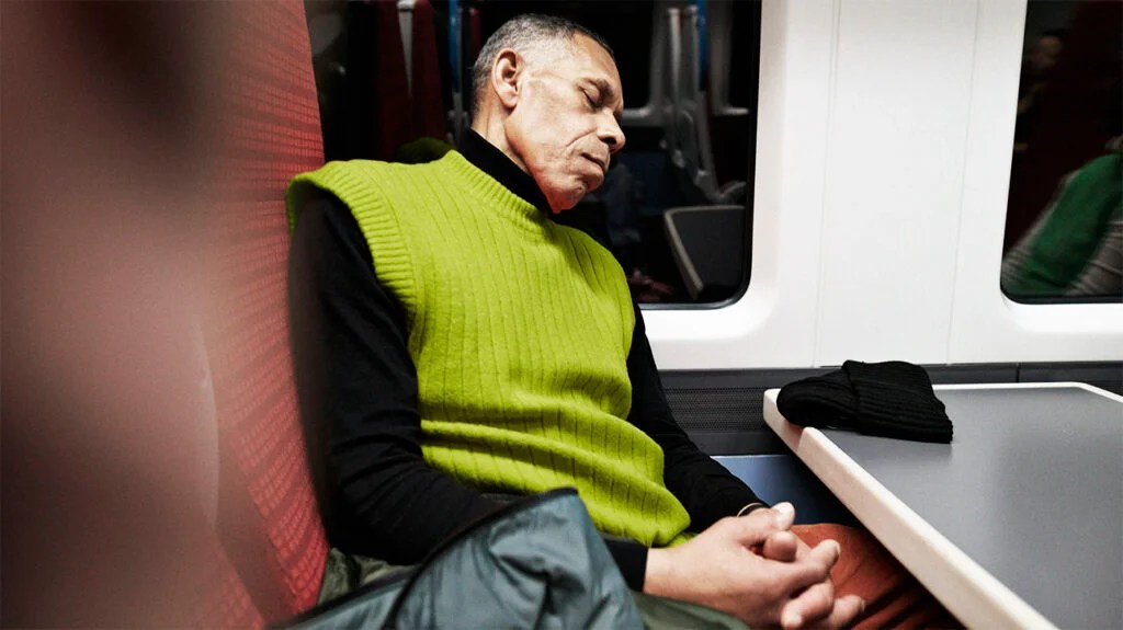 Senior man sleeping in public transport while traveling